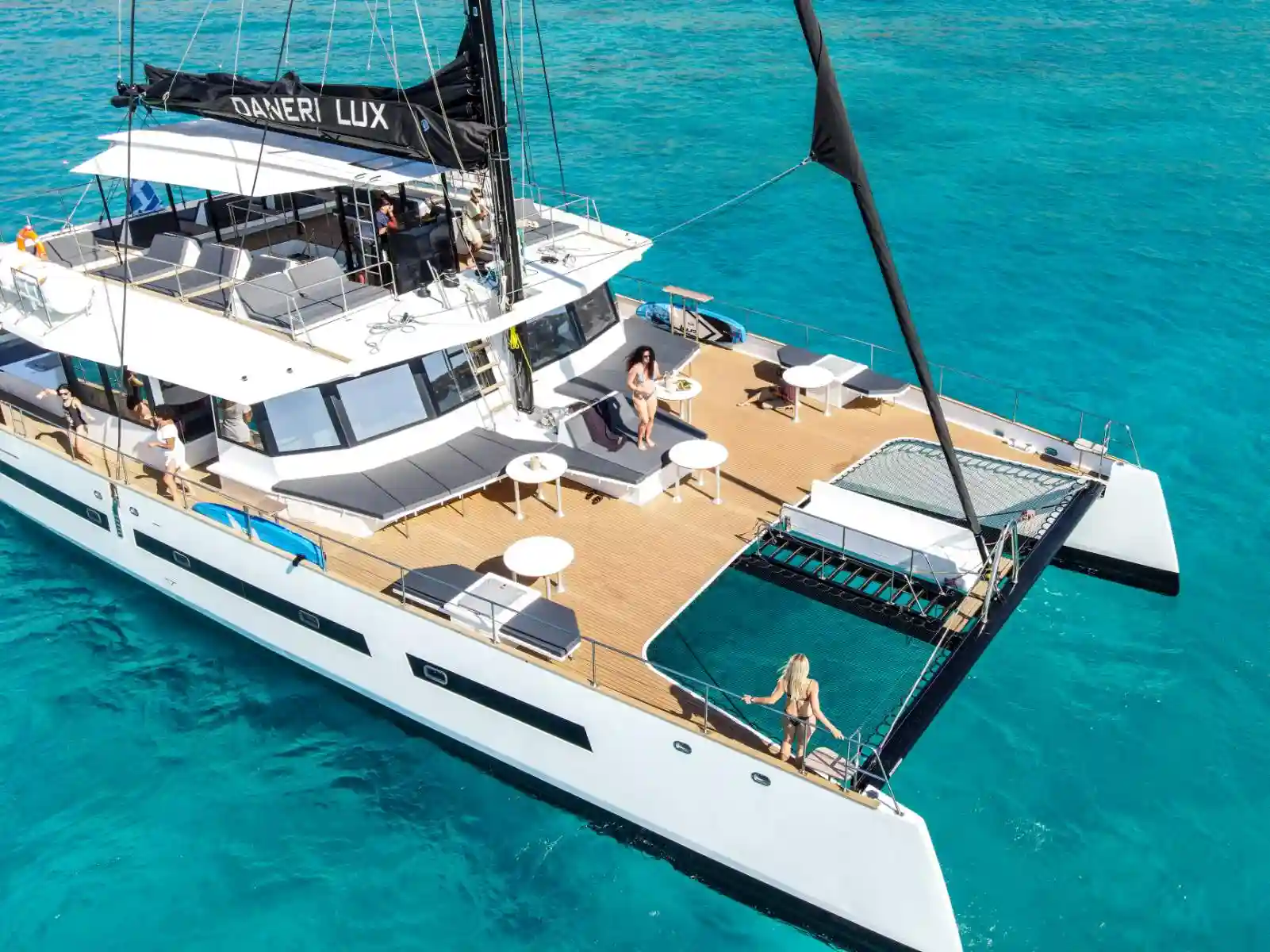 Close up aerial shot of the luxury catamaran Daneri Lux 26 meters with passengers on the spacious deck – Book your cruise with Balos Travel.