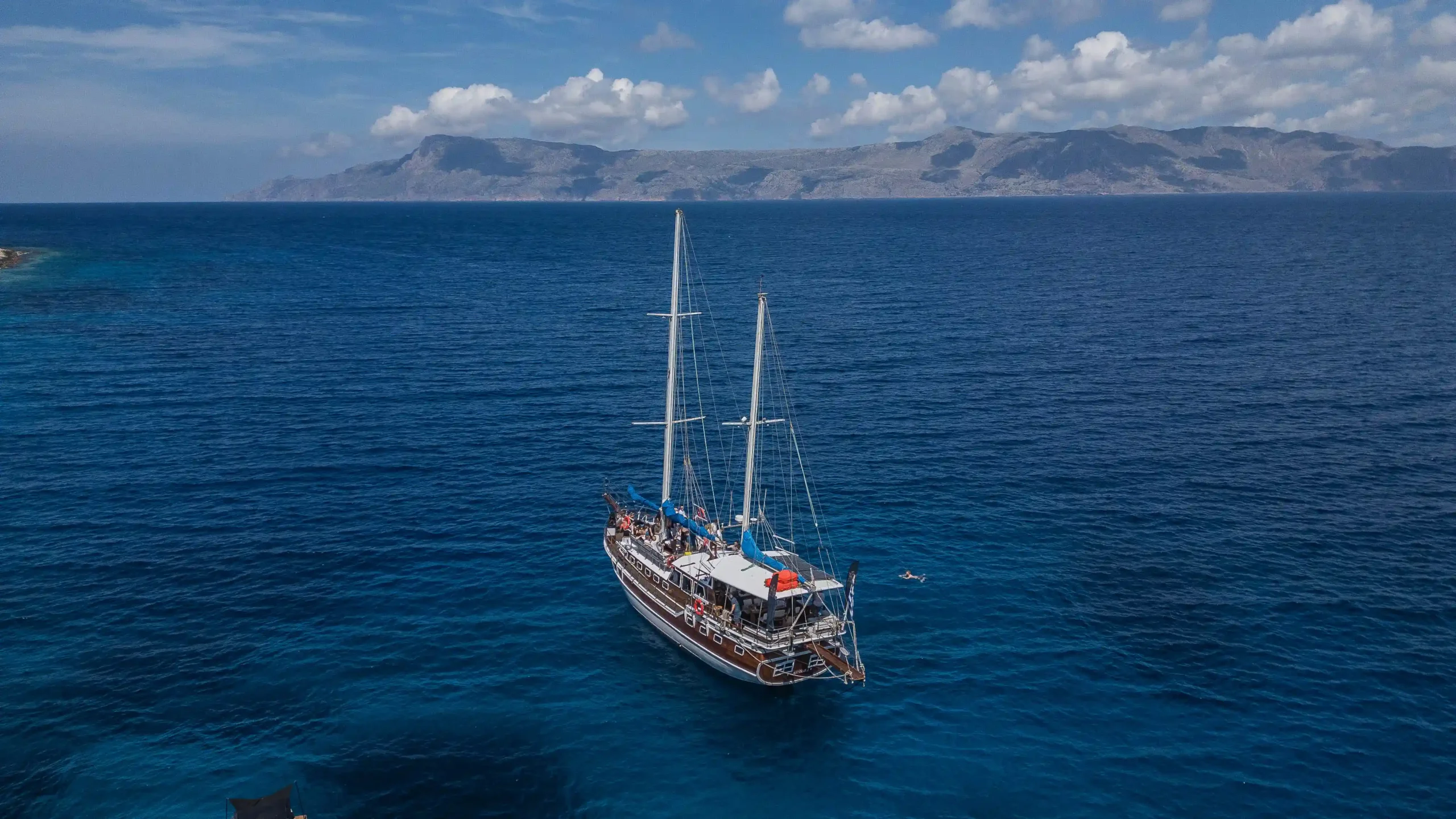 Κοντινή λήψη από ψηλά του πολυτελούς καταμαράν Daneri Lux 26 μέτρων με επιβάτες στο ευρύχωρο κατάστρωμα – Κλείστε την κρουαζιέρα σας με το Balos Travel.