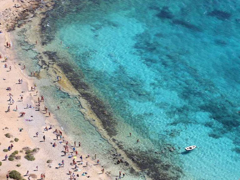 Aerial view of Balos Beach in Crete, Greece, showing crystal-clear turquoise waters and a sandy coastline.