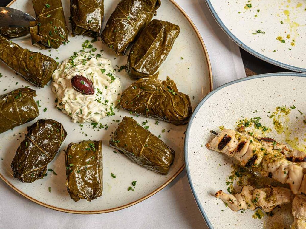 Traditional Greek dish with dolmades, creamy dip, and grilled chicken souvlaki